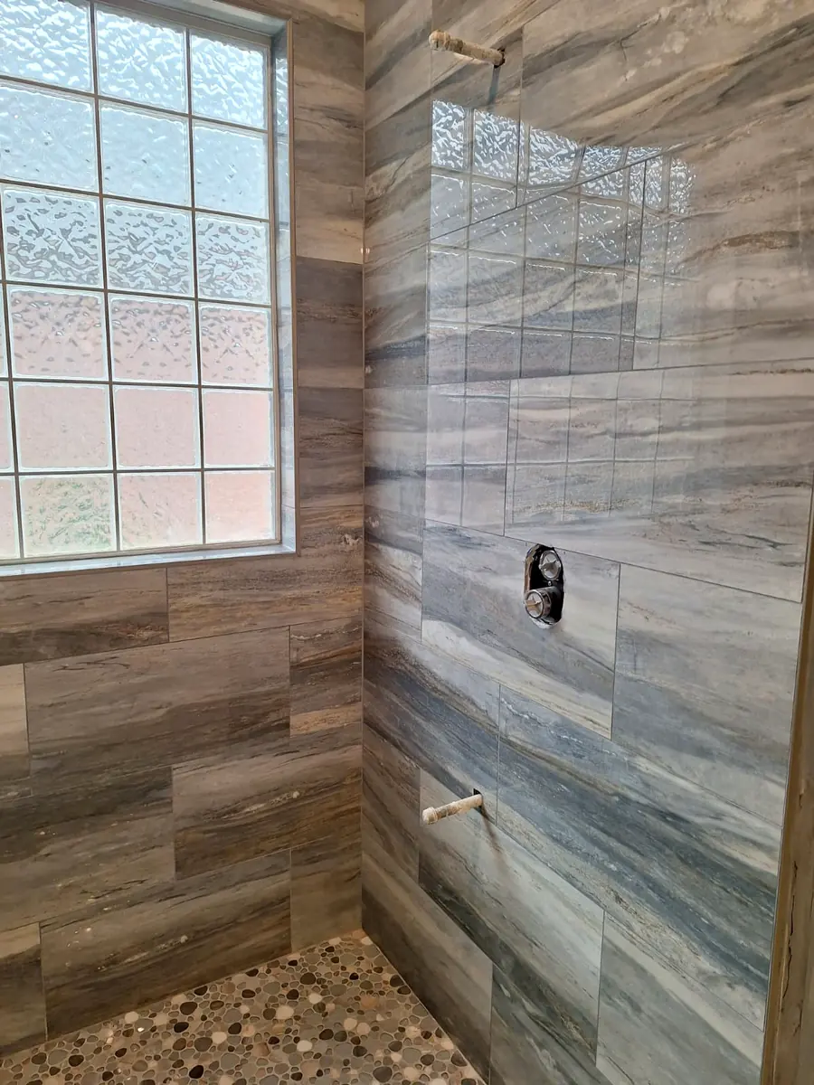 Shower remodel with wood-look tile walls and glass block window